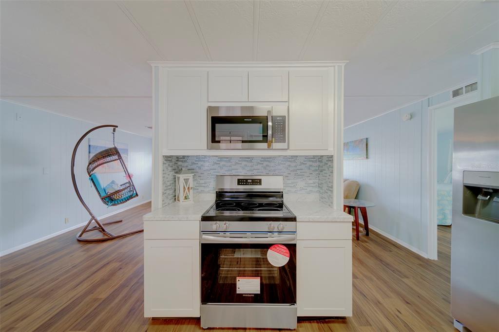 12501 Ulmerton Road, Unit 77 Largo, FL 33774 - Photo 14 of 73 a kitchen with a stove and a wooden floor