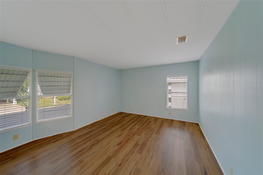 12501 Ulmerton Road, Unit 77 Largo, FL 33774 - Photo 23 of 73 an empty room with wooden floor and windows