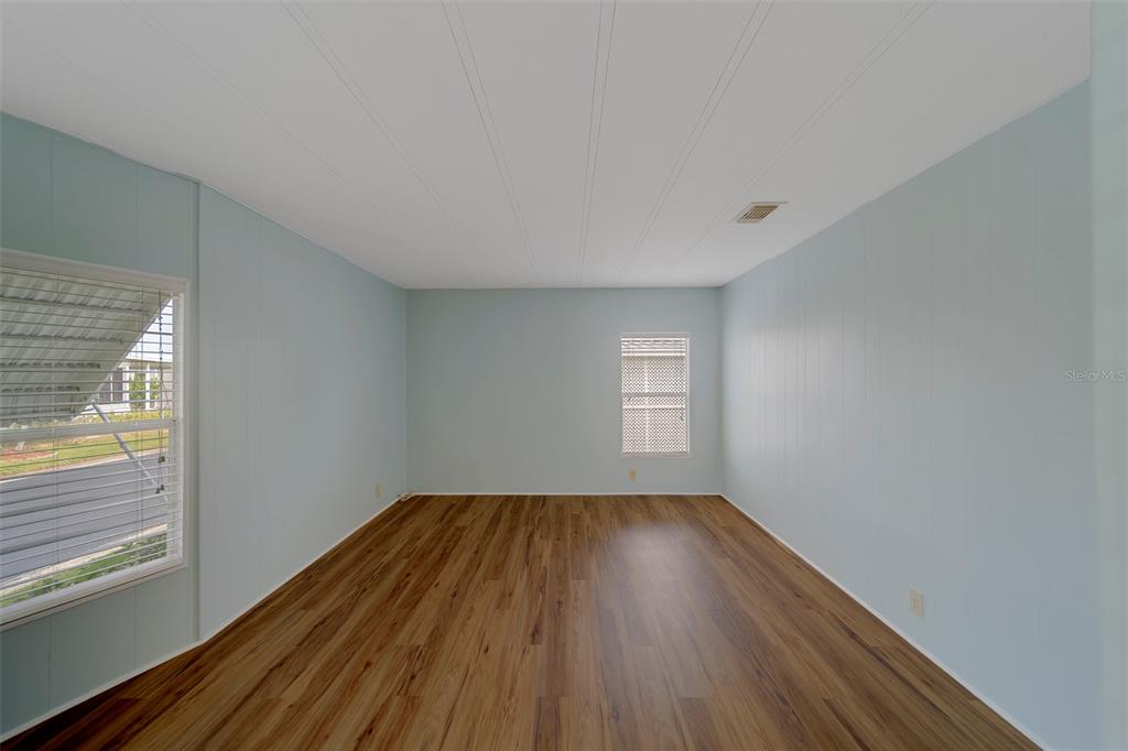 12501 Ulmerton Road, Unit 77 Largo, FL 33774 - Photo 24 of 73 a view of an empty room with wooden floor and a window