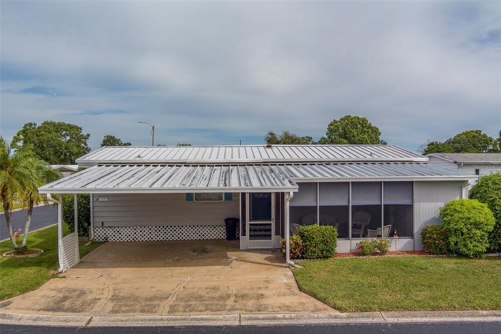 12501 Ulmerton Road, Unit 77 Largo, FL 33774 - Photo 54 of 73 a front view of a house with a yard and garage