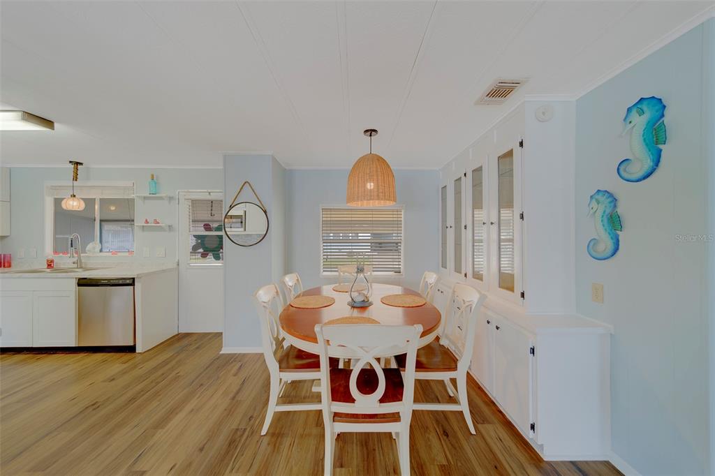 12501 Ulmerton Road, Unit 77 Largo, FL 33774 - Photo 8 of 73 a dining room with wooden floor a chandelier a wooden table and chairs
