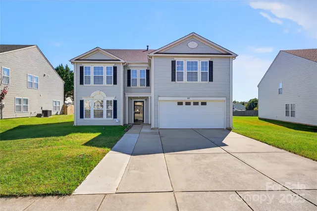 a front view of a house with a yard and garage