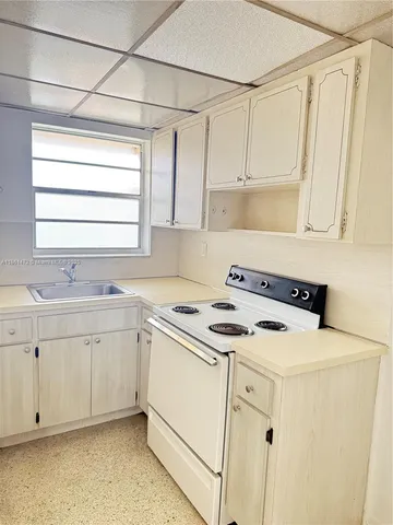 a kitchen with cabinets appliances a sink and a window