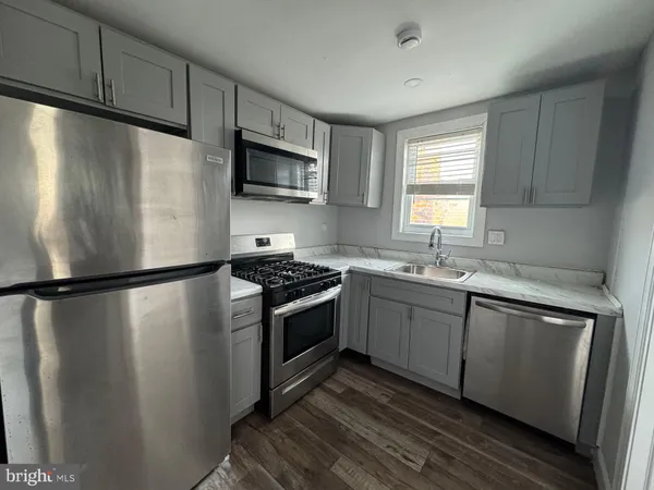 a kitchen with stainless steel appliances a refrigerator sink and microwave