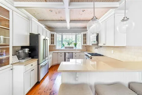 a kitchen with granite countertop a sink appliances cabinets and furniture