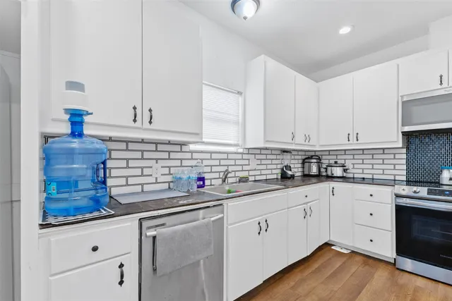 a kitchen with white cabinets and white appliances