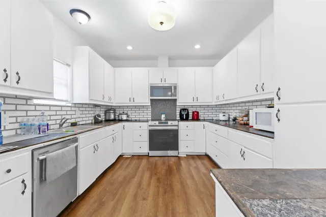 a kitchen with granite countertop a stove top oven sink and cabinets