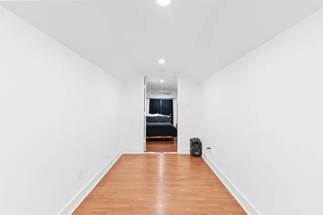 a view of an empty room with wooden floor and cabinet