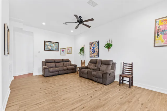 a living room with furniture and a wooden floor