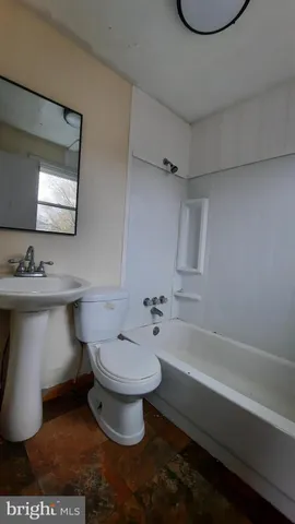 a bathroom with a sink toilet a mirror and bathtub