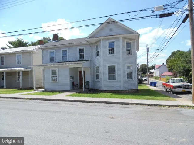 a view of a big house with a yard and plants