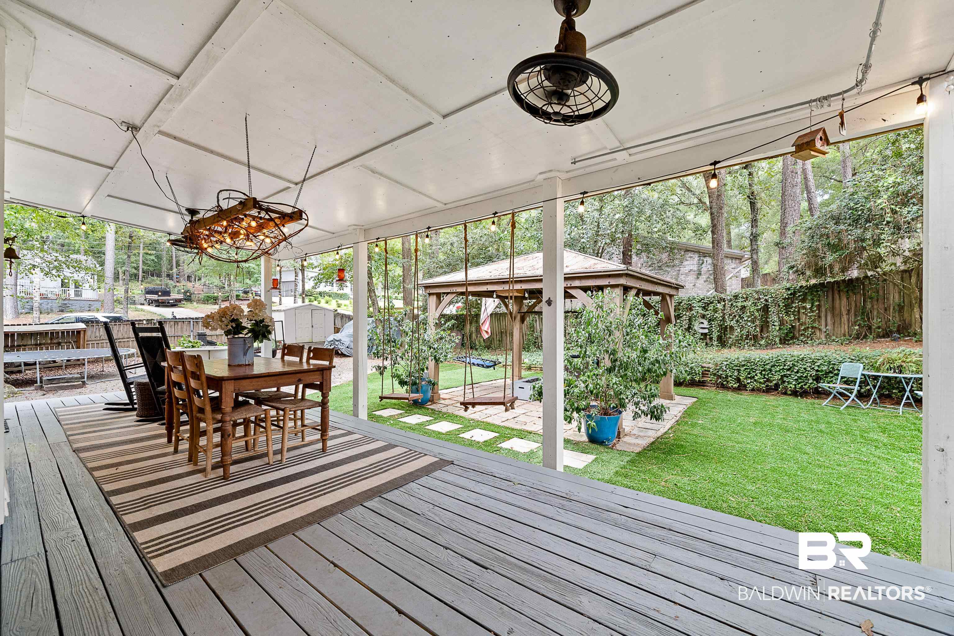 619 Ridgewood Drive Daphne, AL 36526 - Photo 35 of 47 Wooden porch with a storage unit, a gazebo, a fenced backyard, and outdoor dining space