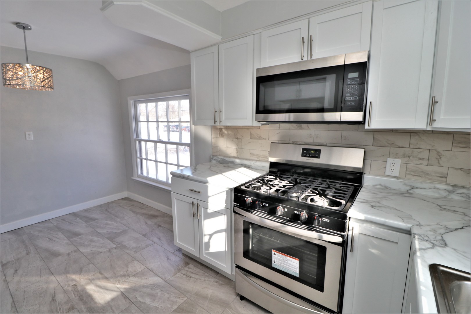 913 North Main Street Rochelle, IL 61068 - Photo 9 of 33 a kitchen with stainless steel appliances a stove a microwave a sink and cabinets