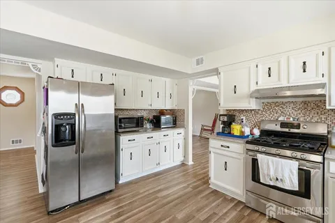 a kitchen with stainless steel appliances a refrigerator sink and cabinets