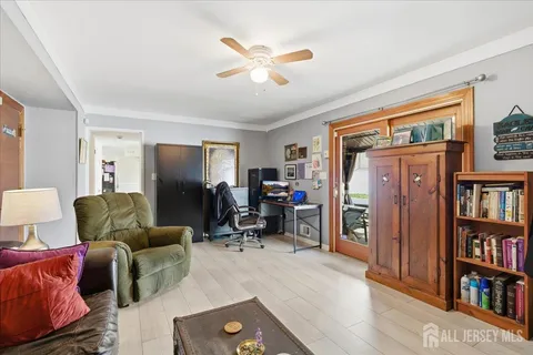 a living room with furniture a ceiling fan and a book shelf