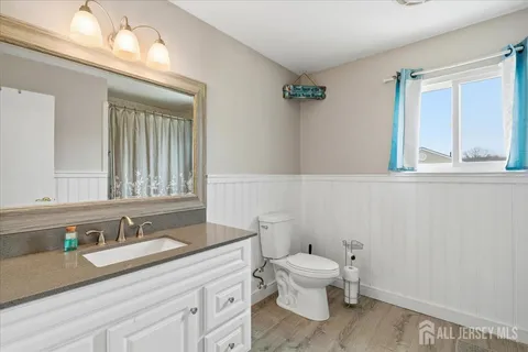 a bathroom with a granite countertop toilet sink and mirror