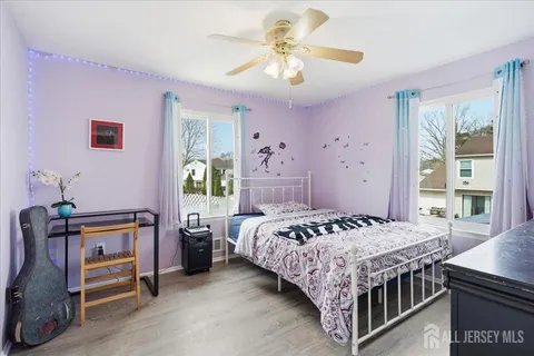 a bedroom with a bed a chandelier and dresser