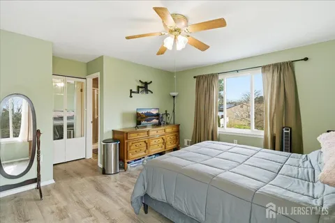a bedroom with a bed and dresser with mirror