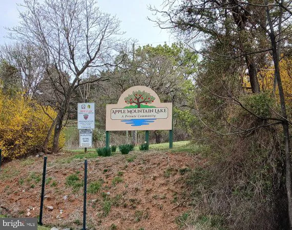 a sign board with a tree in the background