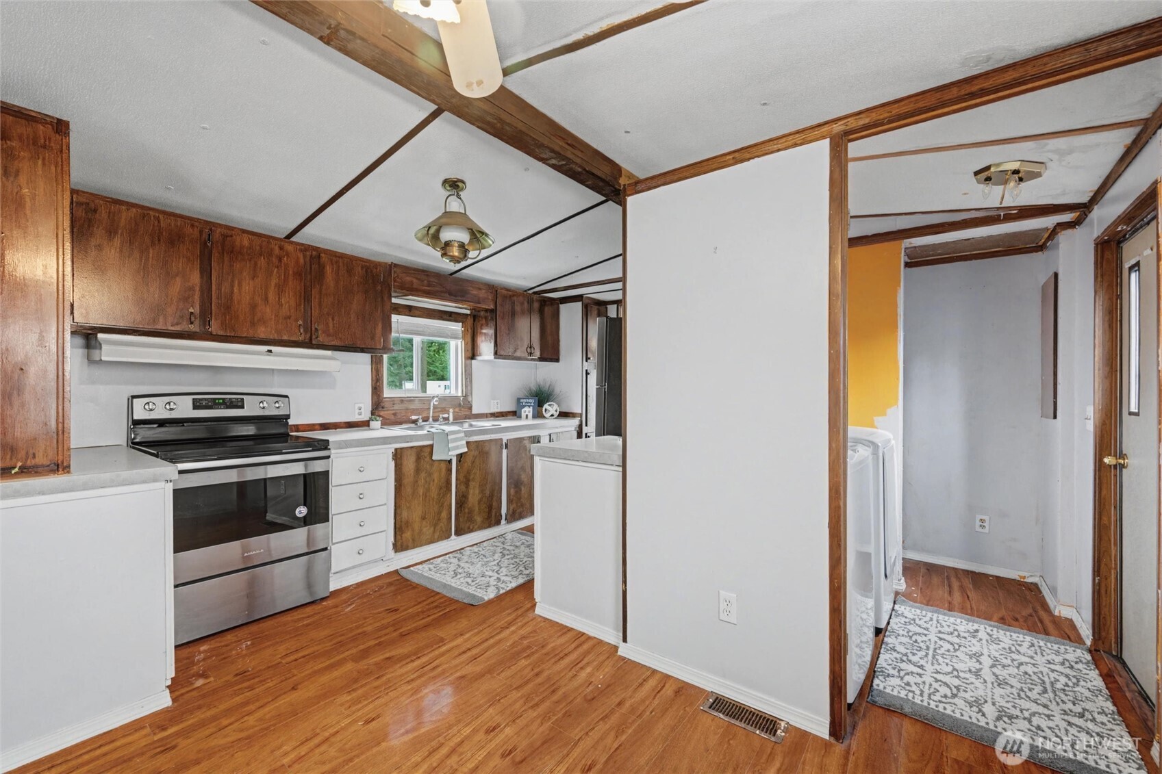 4672 Birch Bay Lynden Road, Unit 157 Blaine, WA 98230 - Photo 8 of 27 a kitchen with stainless steel appliances granite countertop a refrigerator a sink dishwasher a stove and white cabinets with wooden floor