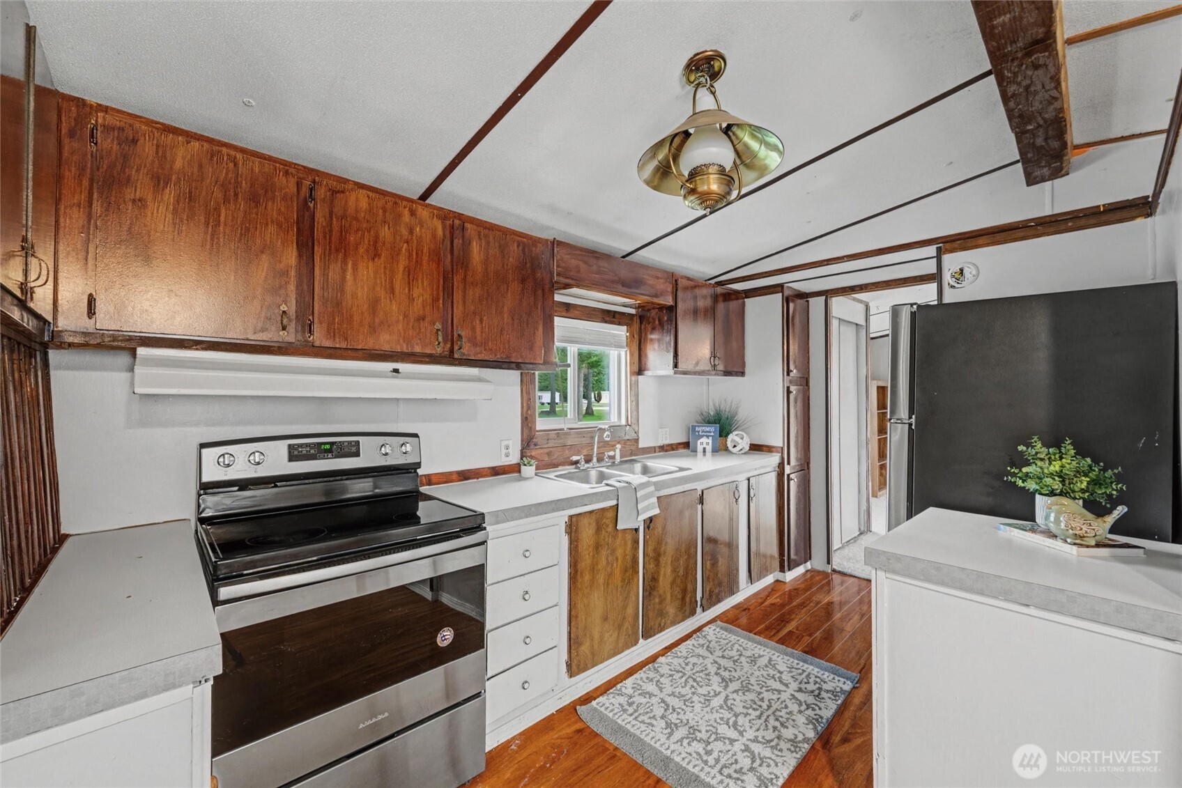 4672 Birch Bay Lynden Road, Unit 157 Blaine, WA 98230 - Photo 9 of 27 a kitchen with stainless steel appliances kitchen island granite countertop a refrigerator a stove and a wooden floors