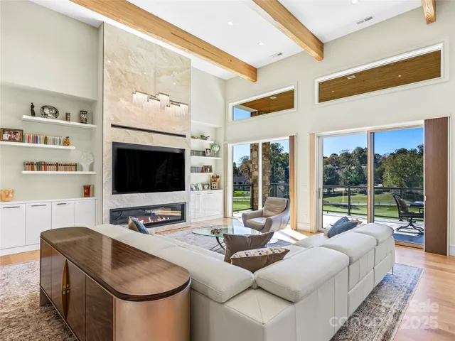 a living room with furniture a flat screen tv and a large window