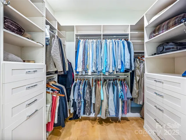 a view of walk in closet with clothes