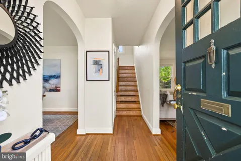 a view of a hallway view with living room and wooden floor