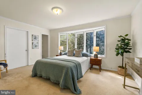 a bedroom with a bed table chair and a window