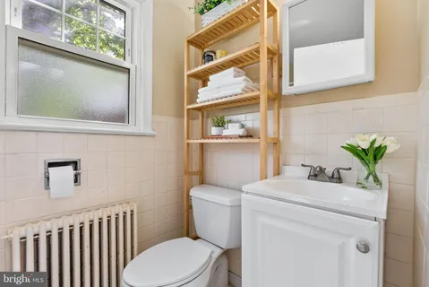 a bathroom with a toilet a sink and a mirror