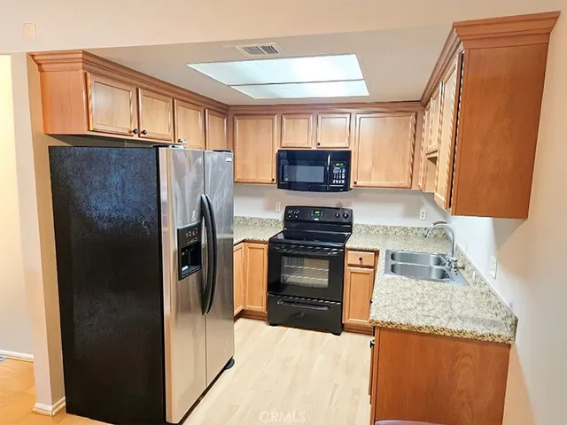 a kitchen with a refrigerator sink and stove top oven