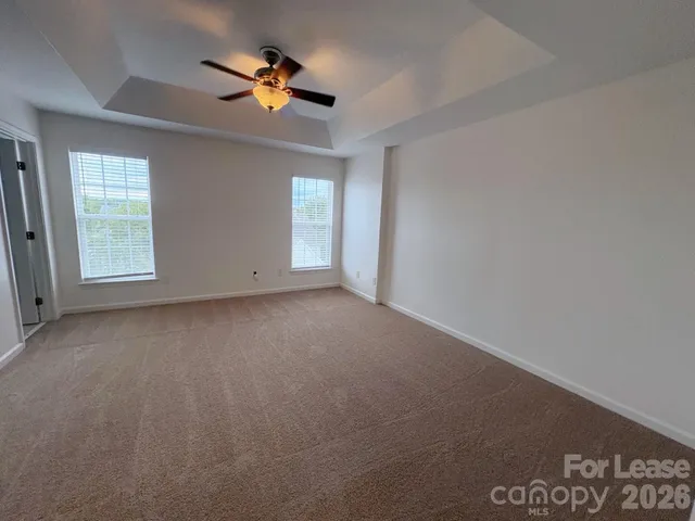 an empty room with a window and a ceiling fan