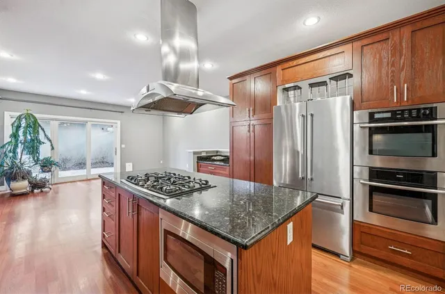 a kitchen with stainless steel appliances granite countertop a stove refrigerator and cabinets