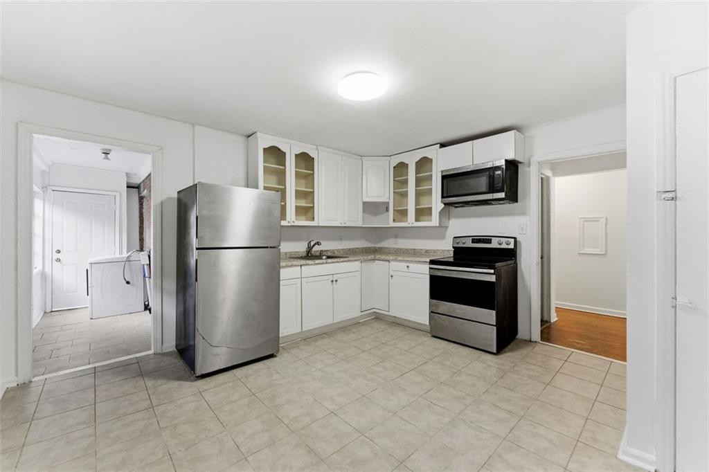 1431 Sharon Street Northwest Atlanta, GA 30314 - Photo 13 of 44 a kitchen with cabinets and stainless steel appliances