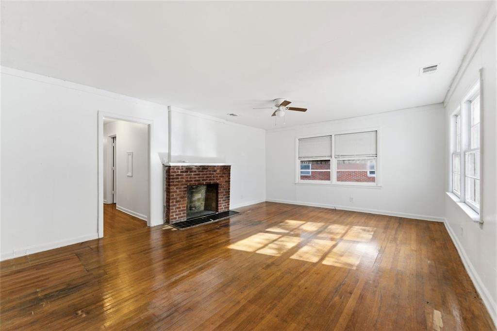 1431 Sharon Street Northwest Atlanta, GA 30314 - Photo 37 of 44 an empty room with wooden floor fireplace and windows
