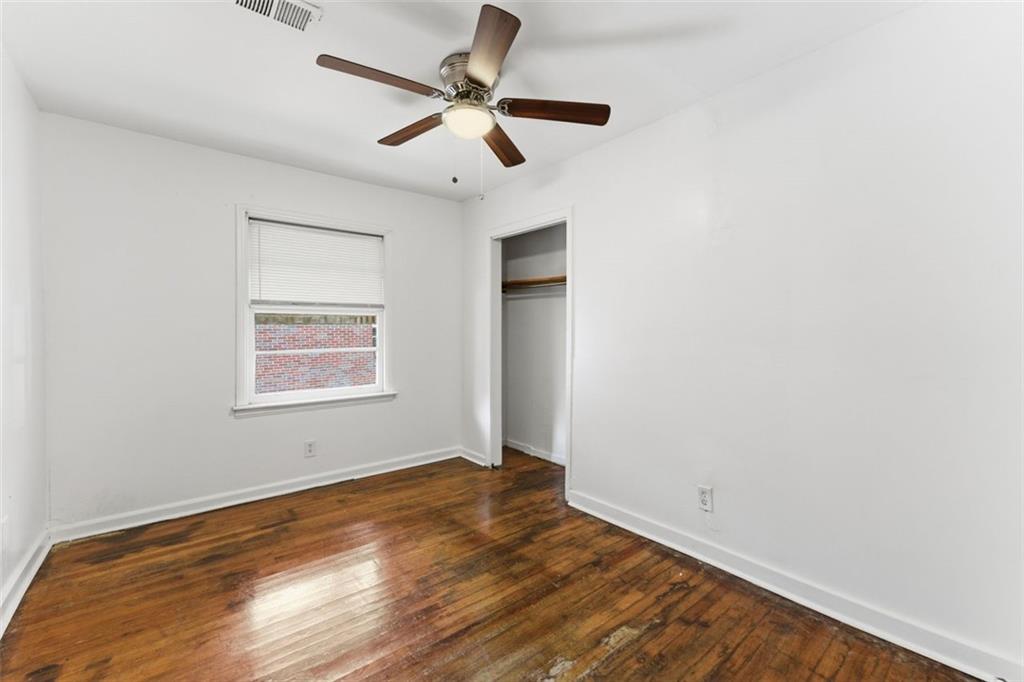 1431 Sharon Street Northwest Atlanta, GA 30314 - Photo 42 of 44 an empty room with wooden floor and ceiling fan