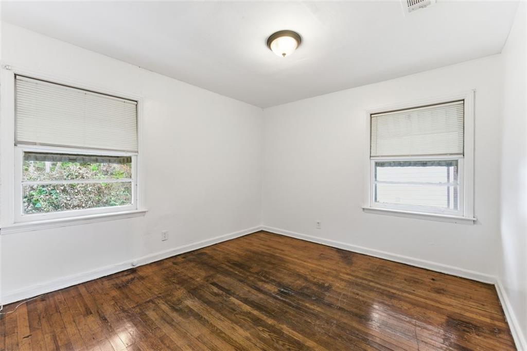 1431 Sharon Street Northwest Atlanta, GA 30314 - Photo 43 of 44 a view of an empty room with wooden floor and a window