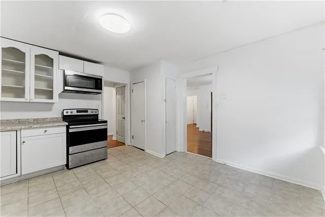 a kitchen with granite countertop a stove and cabinets