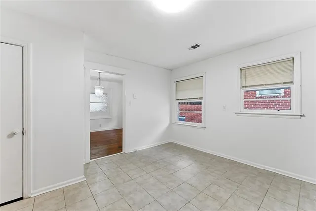 an empty room with wooden floor fireplace and windows