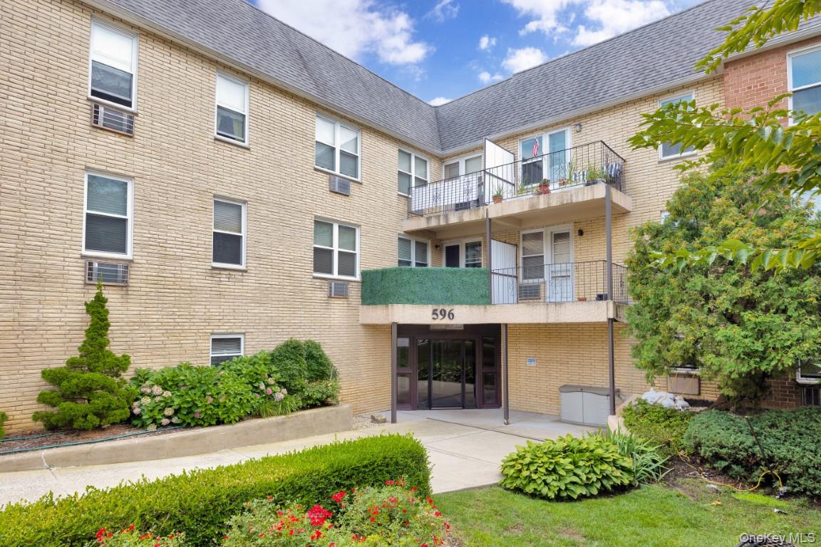 596 Broadway, Unit 10B Lynbrook, NY 11563 - Photo 1 of 1 a front view of a house with a yard and potted plants