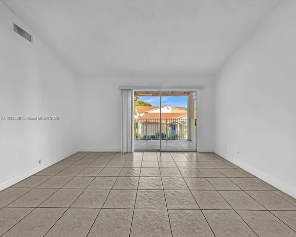 a view of a kitchen with a sink and an empty room