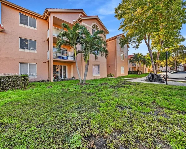 a view of a house with a small yard plants and palm trees