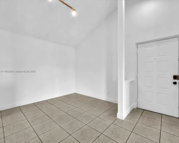 a large white kitchen with stainless steel appliances granite countertop a stove and a sink