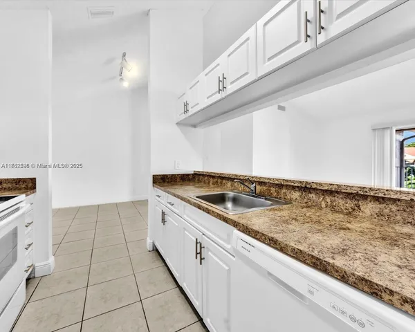 a view of a kitchen with granite countertop white cabinets and a sink