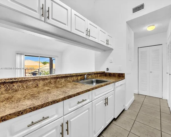 a kitchen with granite countertop a sink and a stove with wooden floor