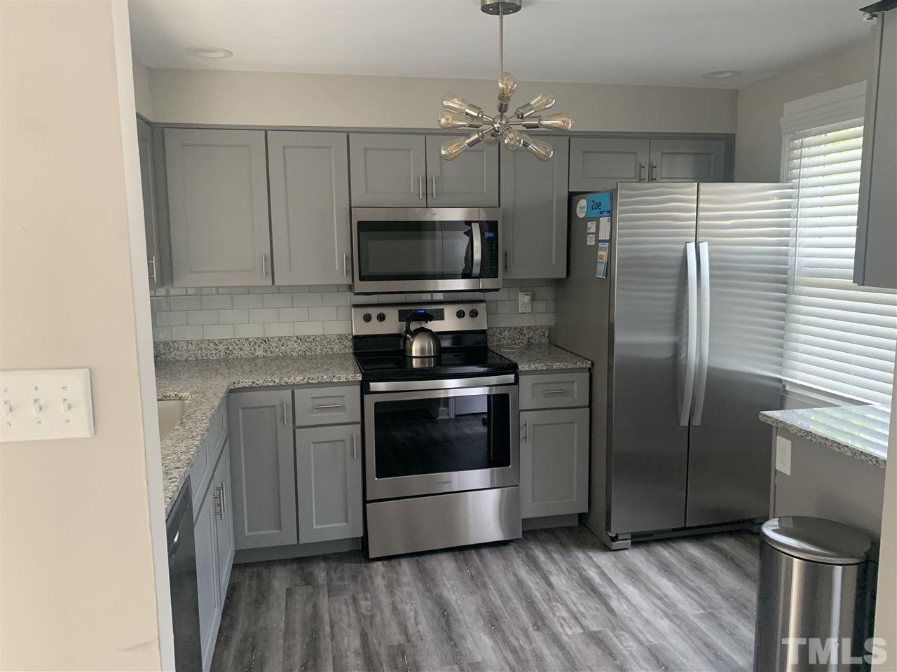 7731 Kelley Court Raleigh, NC 27615 - Photo 1 of 14 a kitchen with stainless steel appliances a stove a refrigerator and a microwave