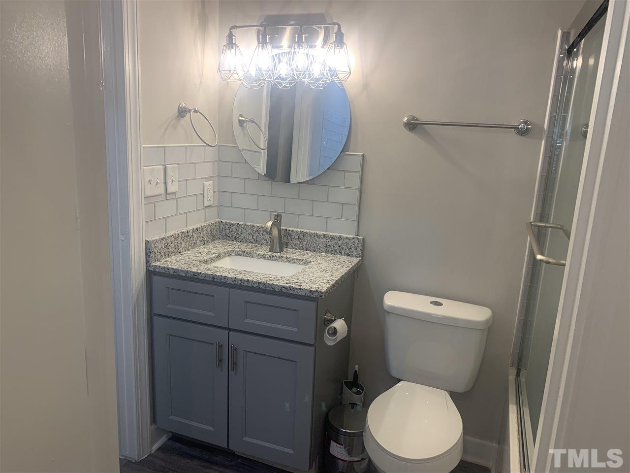 7731 Kelley Court Raleigh, NC 27615 - Photo 11 of 14 a bathroom with a toilet sink and mirror
