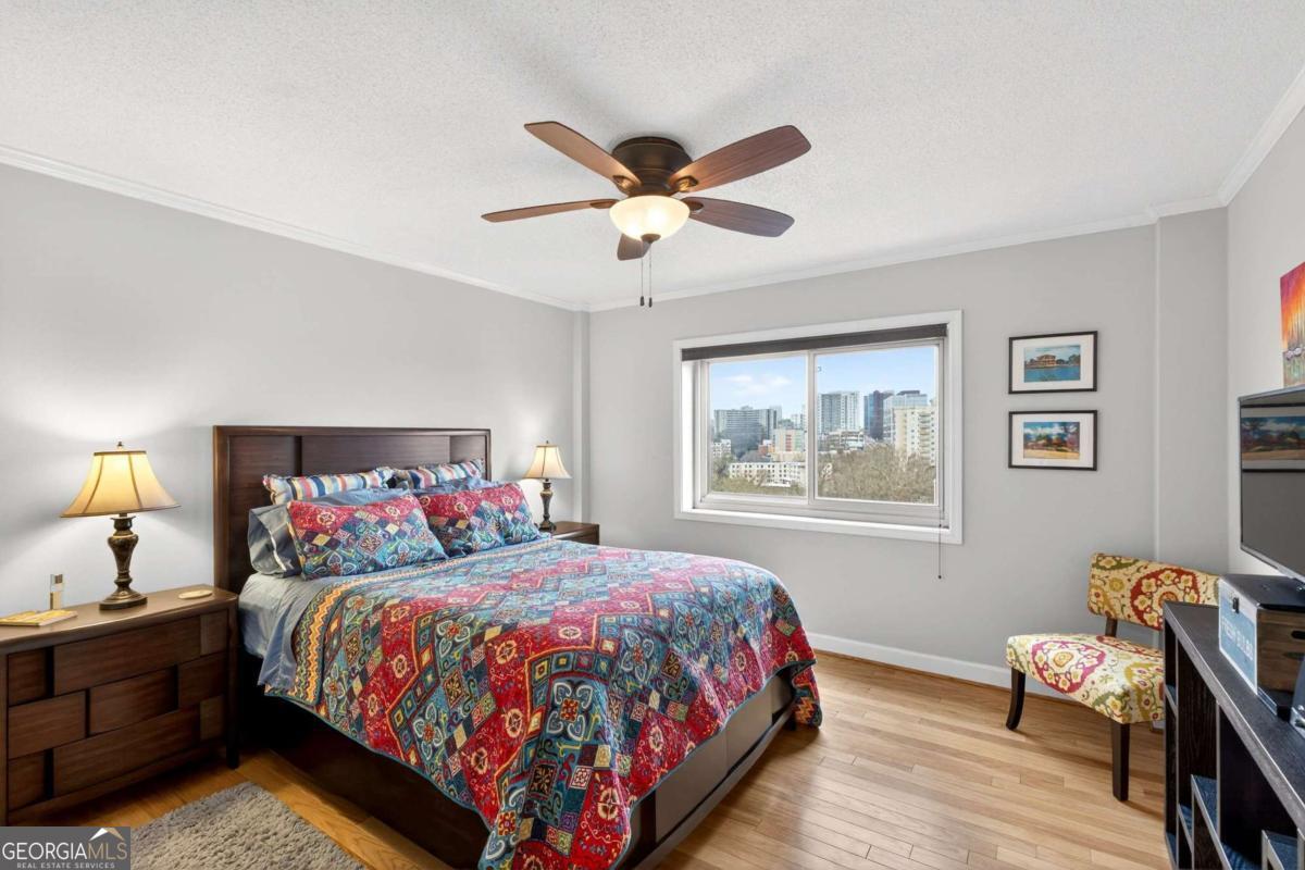 2285 Peachtree Road, Unit 1106 Atlanta, GA 30309 - Photo 12 of 27 a bedroom with a bed and wooden floor