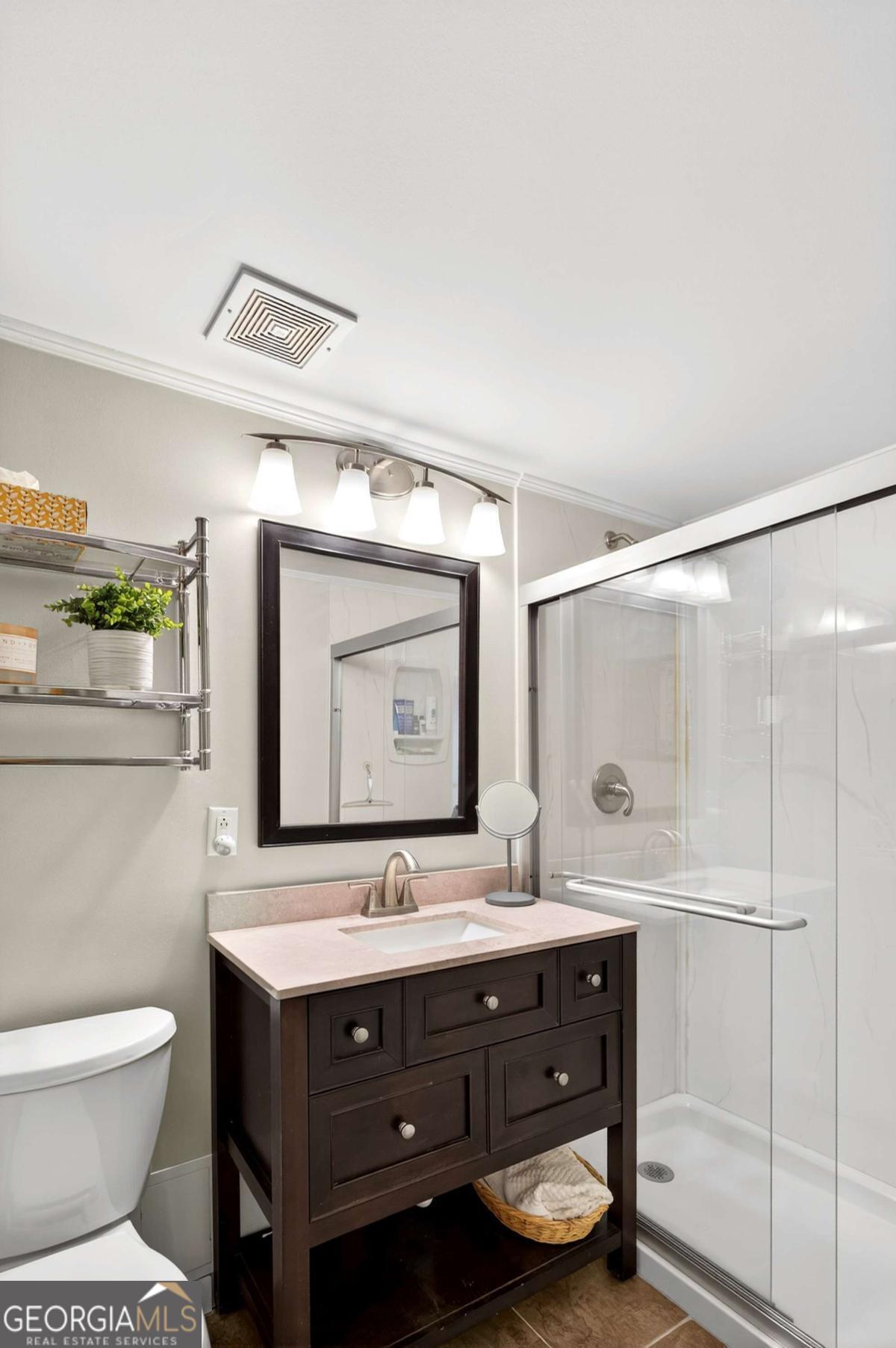 2285 Peachtree Road, Unit 1106 Atlanta, GA 30309 - Photo 18 of 27 a bathroom with a toilet sink double vanity and mirror