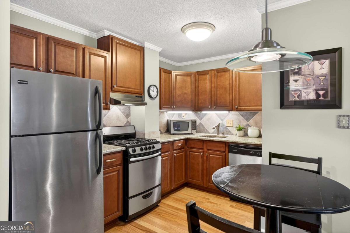 2285 Peachtree Road, Unit 1106 Atlanta, GA 30309 - Photo 3 of 27 a kitchen with stainless steel appliances a stove a refrigerator and a refrigerator